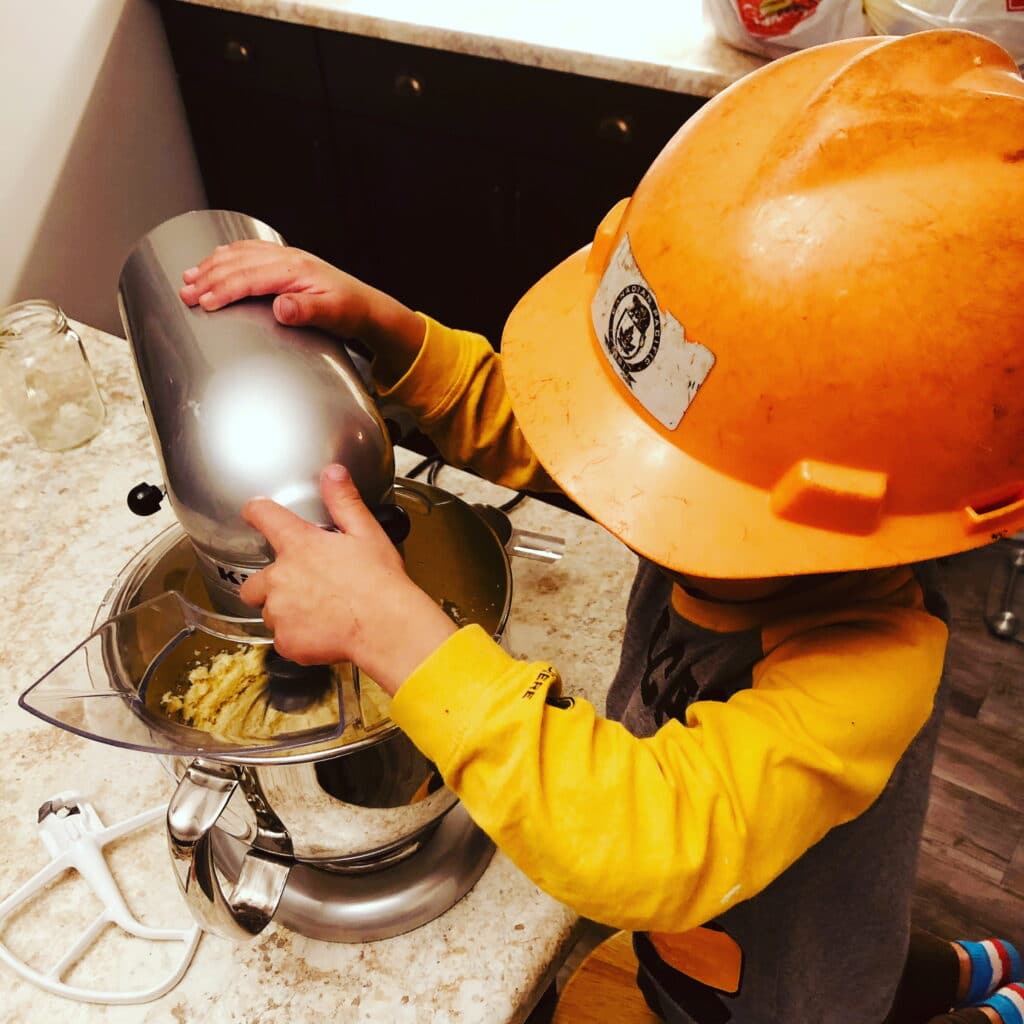 Little boy baking with a hard hat on