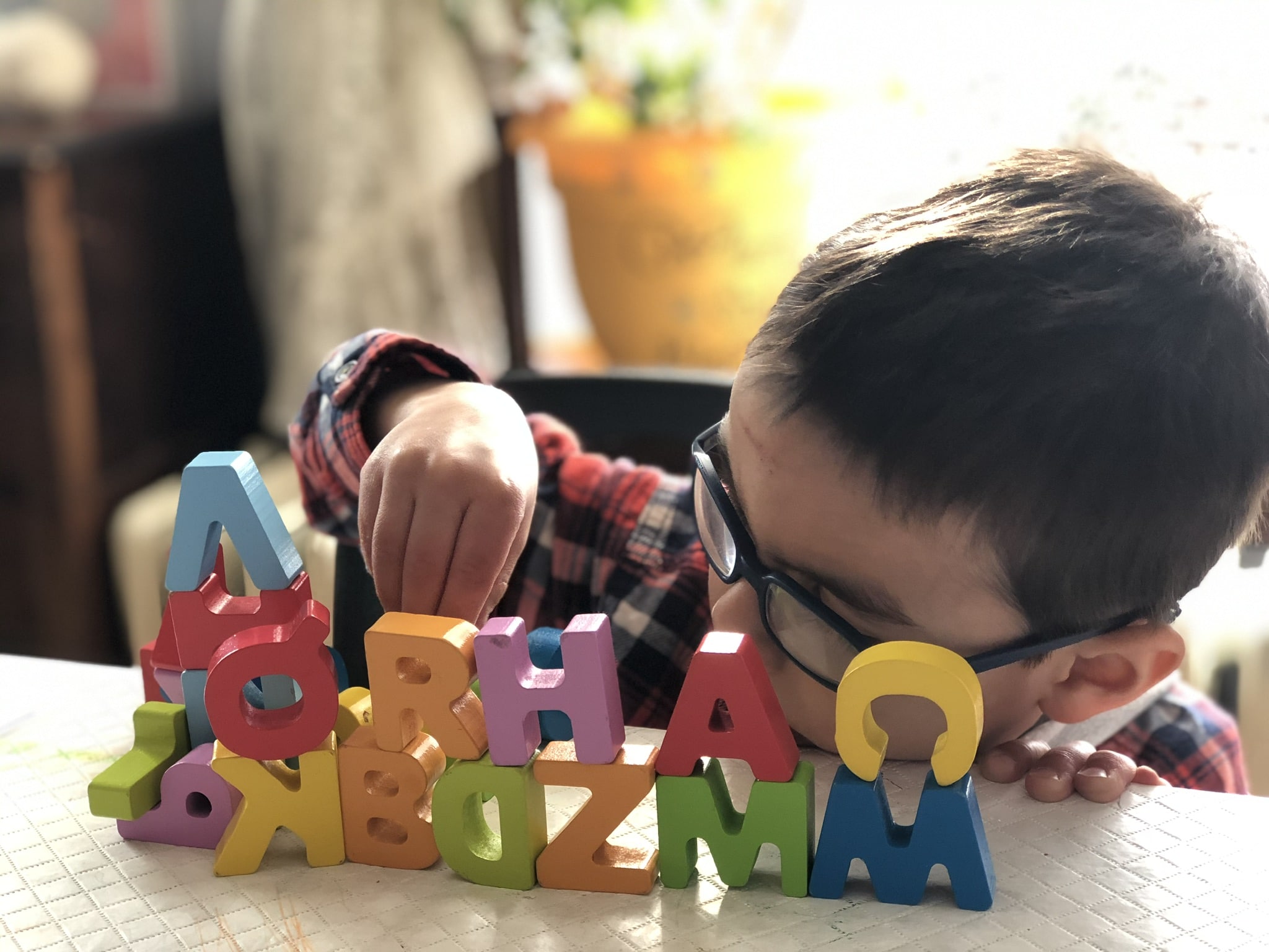 Little boy playing with alphabet puzzles is an encouragement for homeschool moms that it's about the process, not perfection.