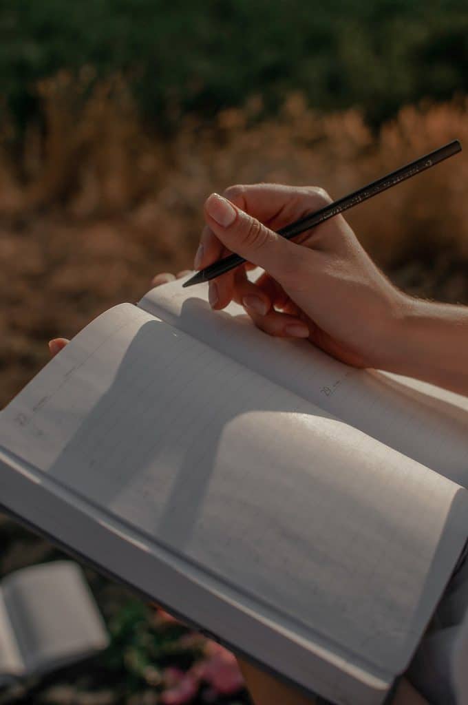 A woman sits with an open notebook and works on choosing a word for the year.