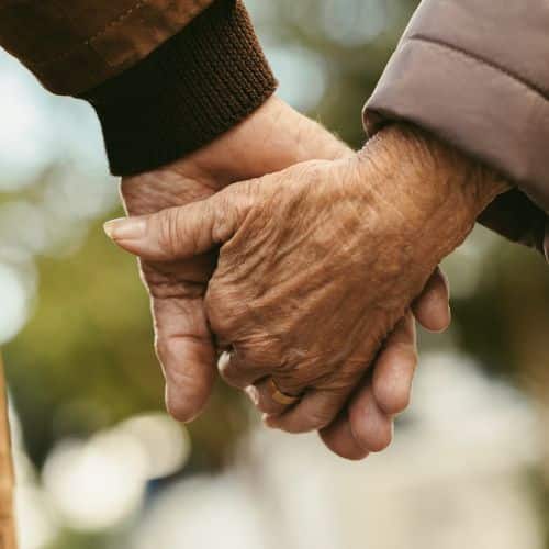 An elderly couple holding hands is an example of how to Nurture Your Marriage