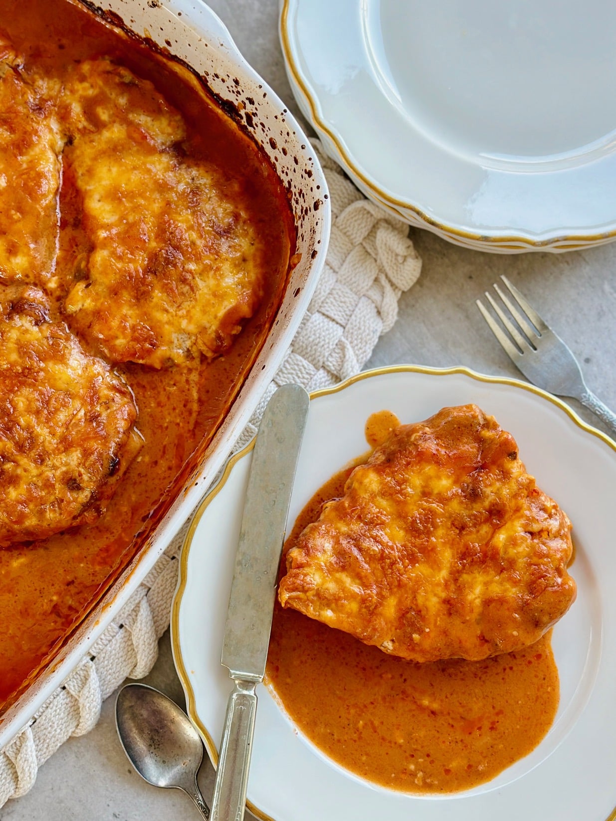 a plated easy baked pork chop smothered in creamy tomato sauce and ready to enjoy!